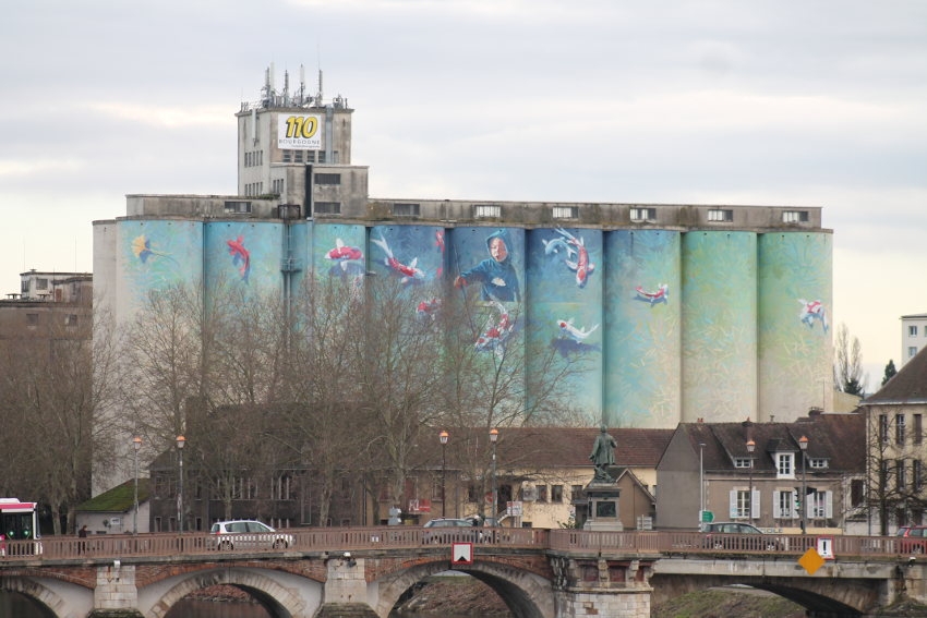 « Depuis trente ans, les silos du BATARDEAU à Auxerre sont prétextes à discussion. Enduit d’une gigantesque fresque picturale de 1 800 mètres carrés, œuvre de l’artiste Florent MAUSSION, cet immense réservoir à grains, propriété de la coopérative « 110 Bourgogne », pourrait se négocier à la vente dans les prochaines semaines. Mais, à quel prix pour qu’il ait entente ? ».