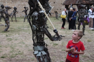 « Même pas peur ! Un garçonnet s’aventure un peu trop près de l’impressionnante créature métallique avant d’engager une conversation unilatérale. Et de vivre pleinement ses rêves de gosse grâce à un imaginaire débordant. A l’instar de l’artiste sculpteur et plasticien, Jean-François BROSSIER, qui a présenté une trentaine de ces statues de ferraille lors d’une nocturne réussie au château…On le voit en grande discussion avec Jean-Claude RANSON, propriétaire du Domaine du Bouloy…».