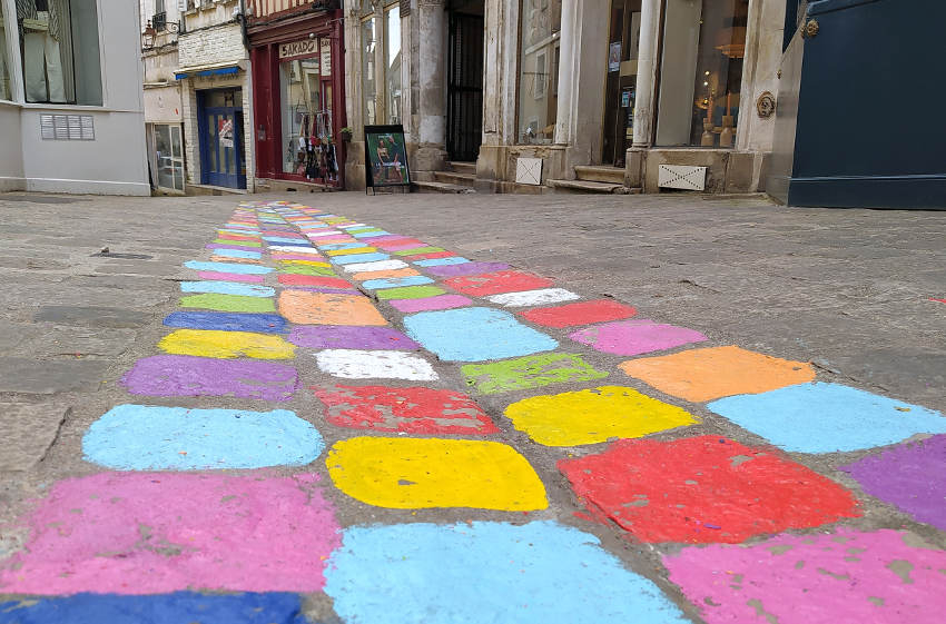 « Les pavés de la rue Fécauderie à Auxerre changent de couleur à l’initiative de l’artiste plasticienne Catherine RYMARSKI ! Une manière de remettre un peu de lumière et de gaieté dans le quotidien des Icaunais qui en ont grandement besoin dans ce monde terne, en noir et blanc ! ».